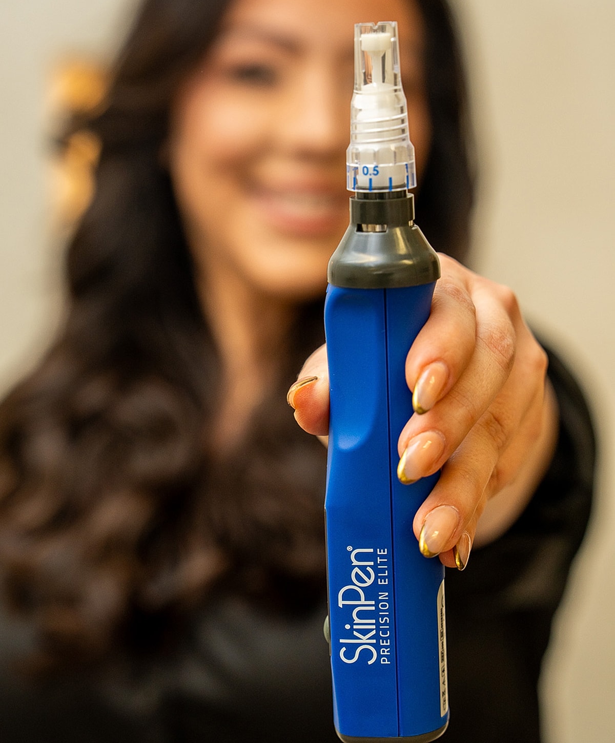 Person holding SkinPen device for skincare treatment.